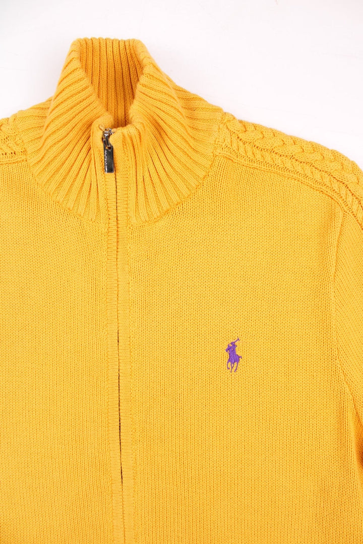 Ralph Lauren Sport zip cardigan in a mustard yellow colourway with the Ralph Lauren logo embroidered on the front chest panel. The knit has a cable knit pattern down the sleeves, ands two front pockets.