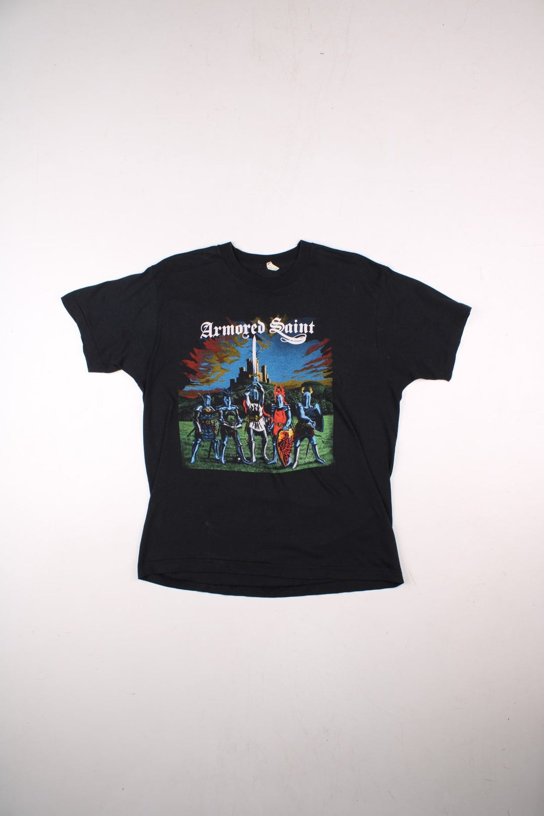 Vintage 80's Armored Saint March Of The Saint single stitch T-Shirt in a black colourway with a medieval knights graphic printed on the front, and the bands pictured and spell out printed on the back.