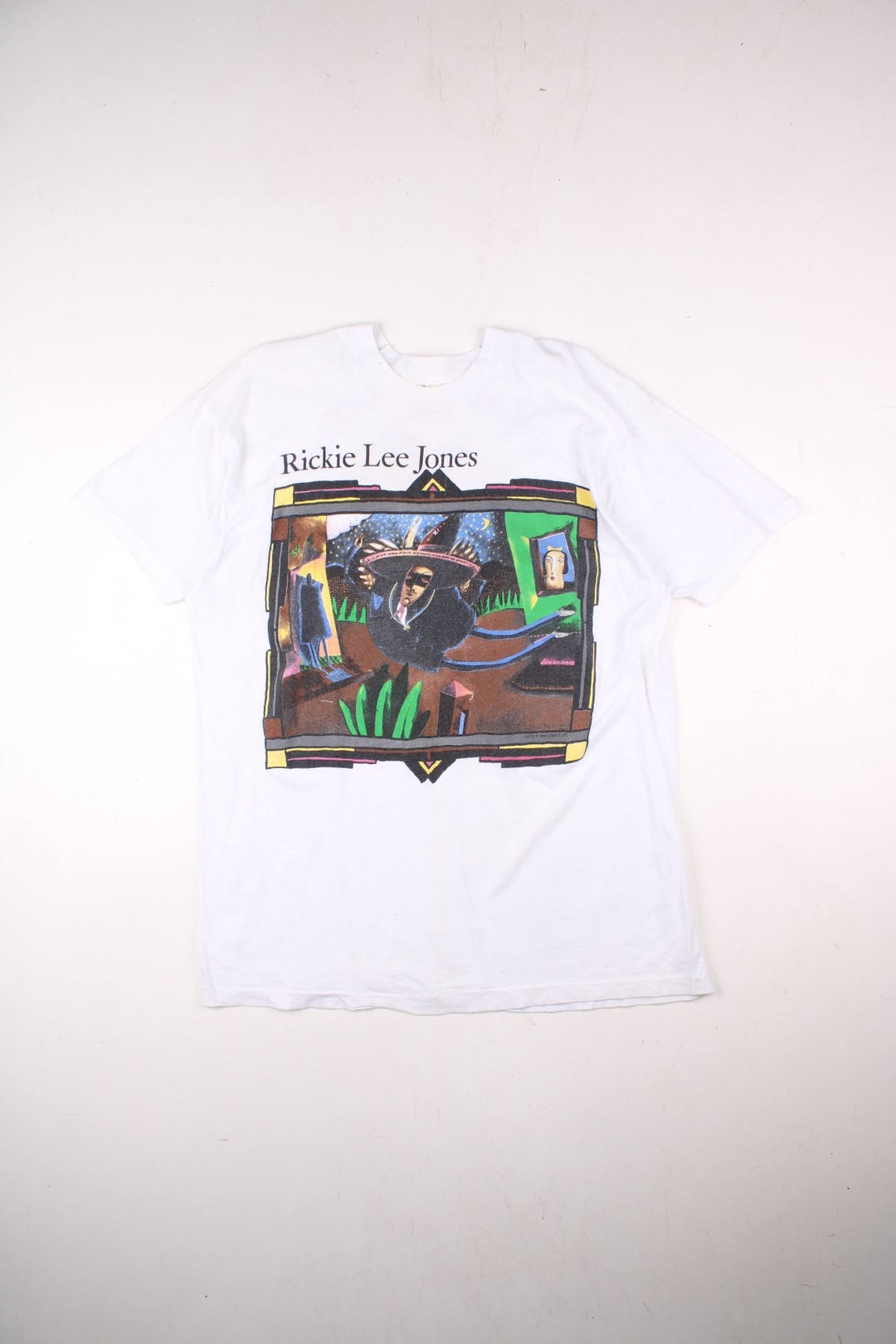 Vintage 1990 Rickie Lee Jones Flying Cowboys Tour T-Shirt in a white colourway, single stitch, and has large art graphic and spell out printed on the front, and on the back has the tour dates and spell out.