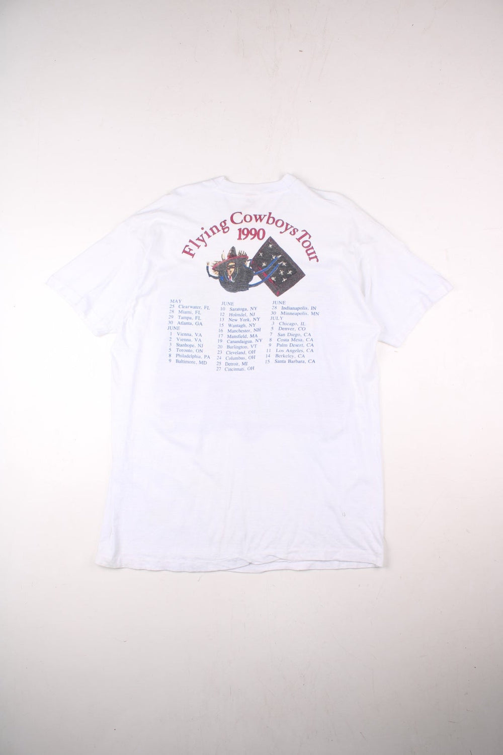 Vintage 1990 Rickie Lee Jones Flying Cowboys Tour T-Shirt in a white colourway, single stitch, and has large art graphic and spell out printed on the front, and on the back has the tour dates and spell out.