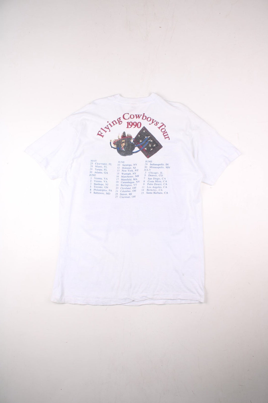 Vintage 1990 Rickie Lee Jones Flying Cowboys Tour T-Shirt in a white colourway, single stitch, and has large art graphic and spell out printed on the front, and on the back has the tour dates and spell out.