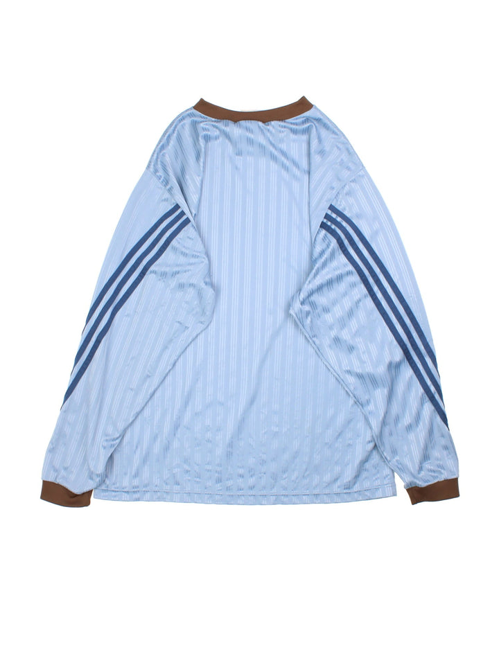 Vintage 90's Adidas Long Sleeve Training Top in a blue colourway with brown collar and cuffs, has the iconic three stripes going down the sleeves, and the logo printed on the front.