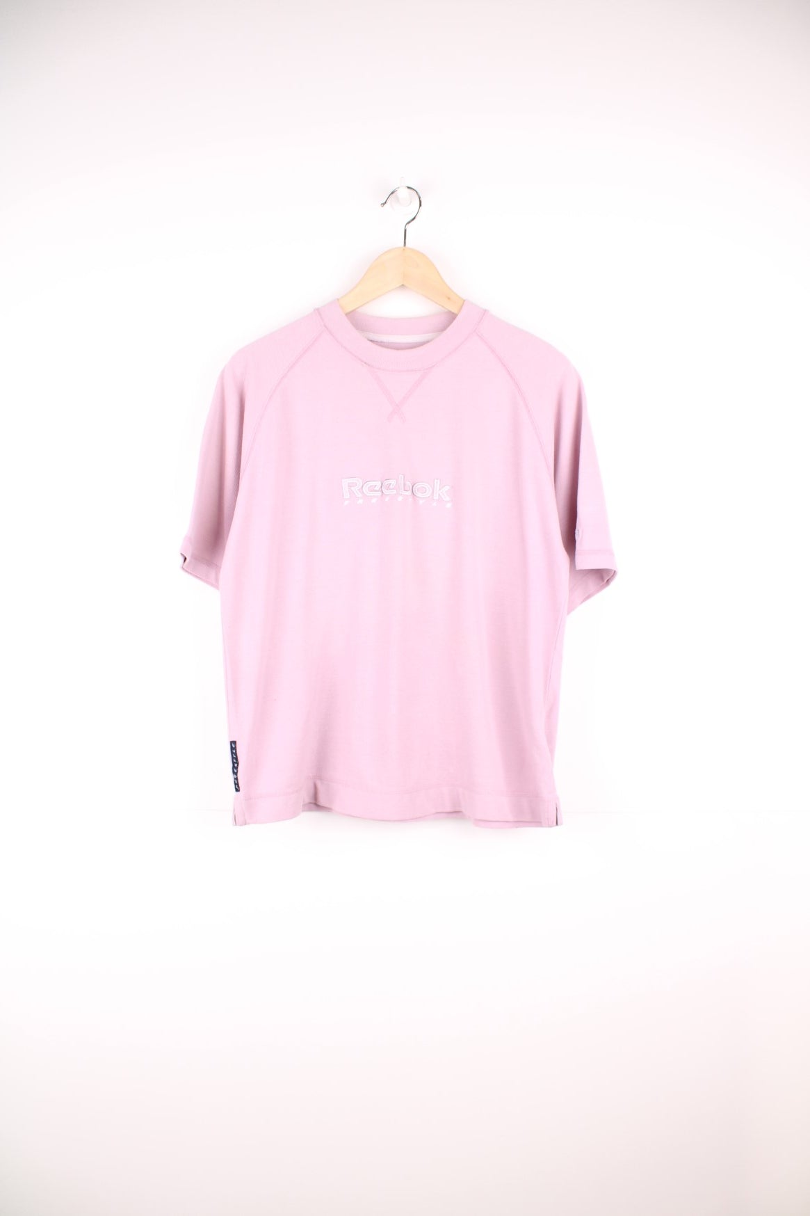 Pale pink Reebok Freestyle spellout t-shirt with small logo tag on left sleeve, and &