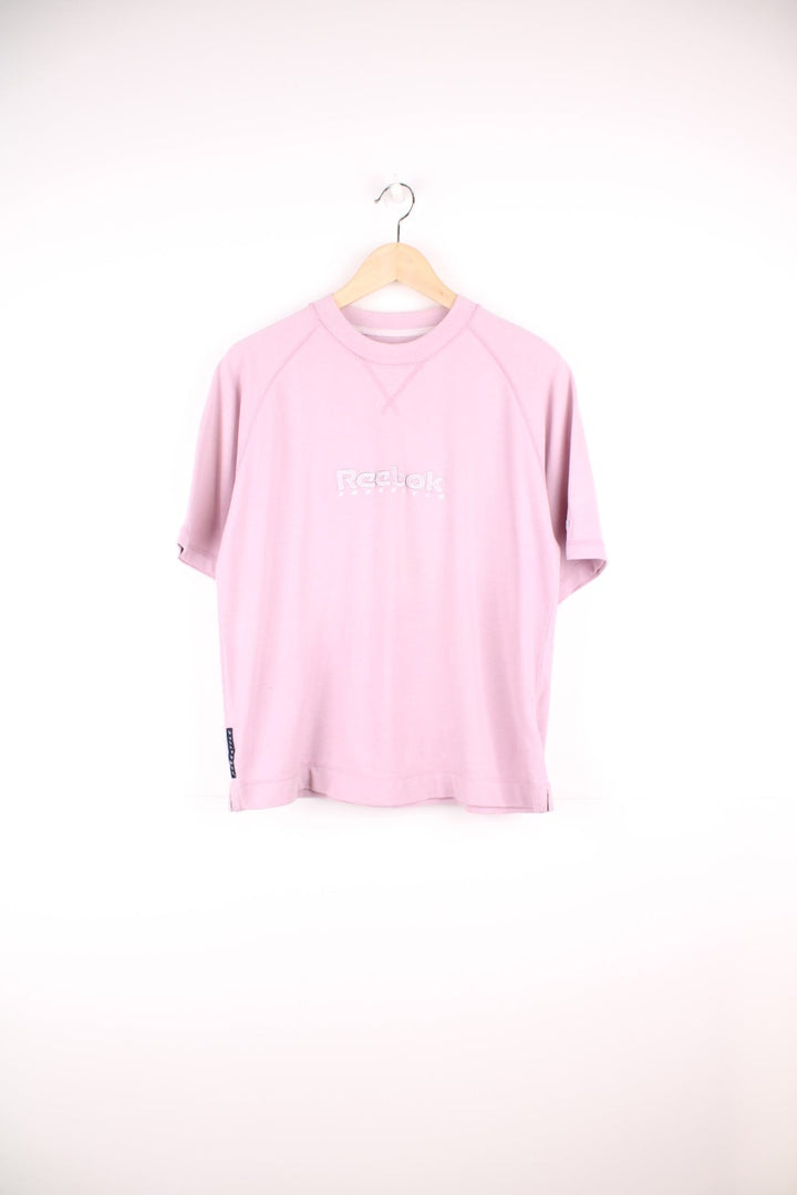 Pale pink Reebok Freestyle spellout t-shirt with small logo tag on left sleeve, and 'Freestyle' tag on lower right hem.