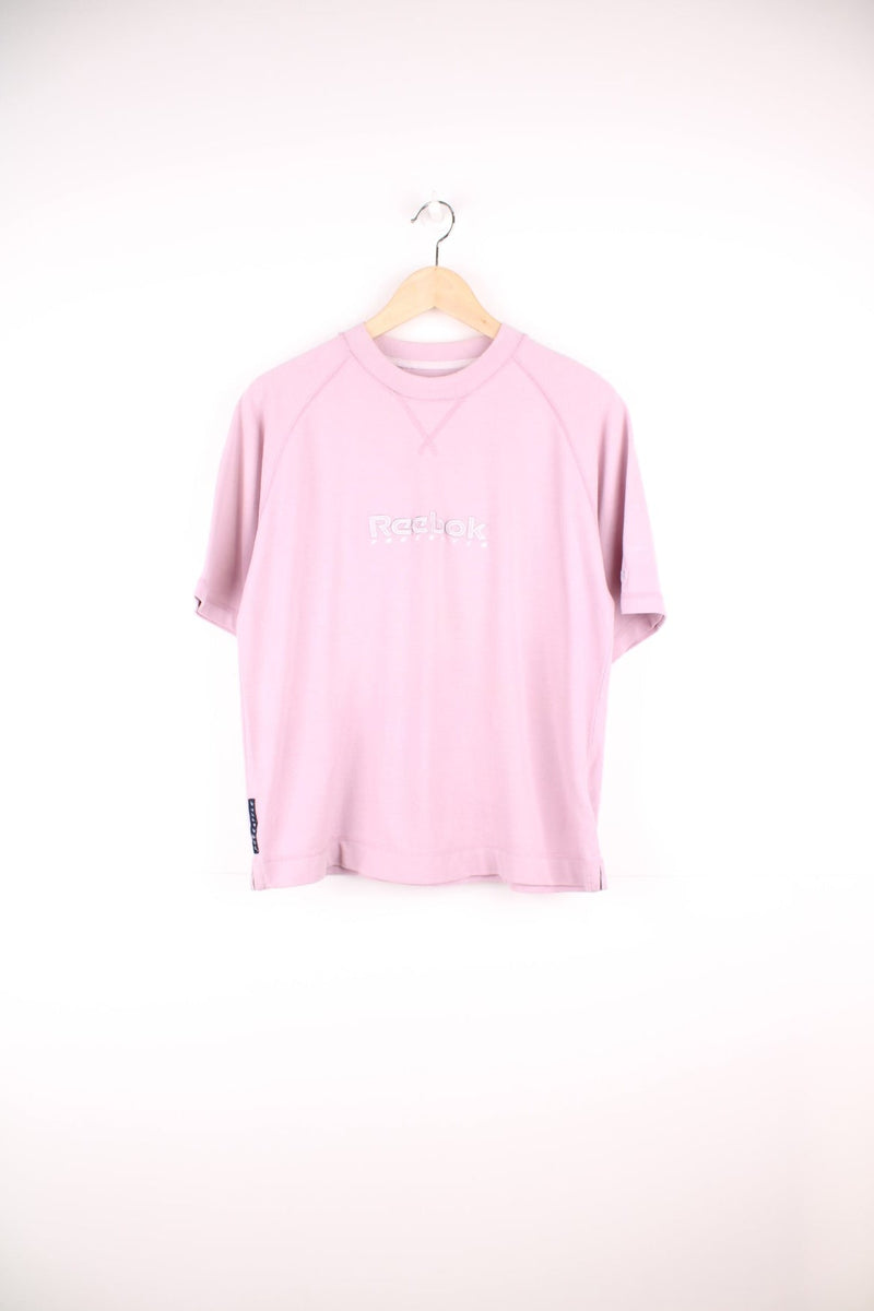 Pale pink Reebok Freestyle spellout t-shirt with small logo tag on left sleeve, and 'Freestyle' tag on lower right hem.