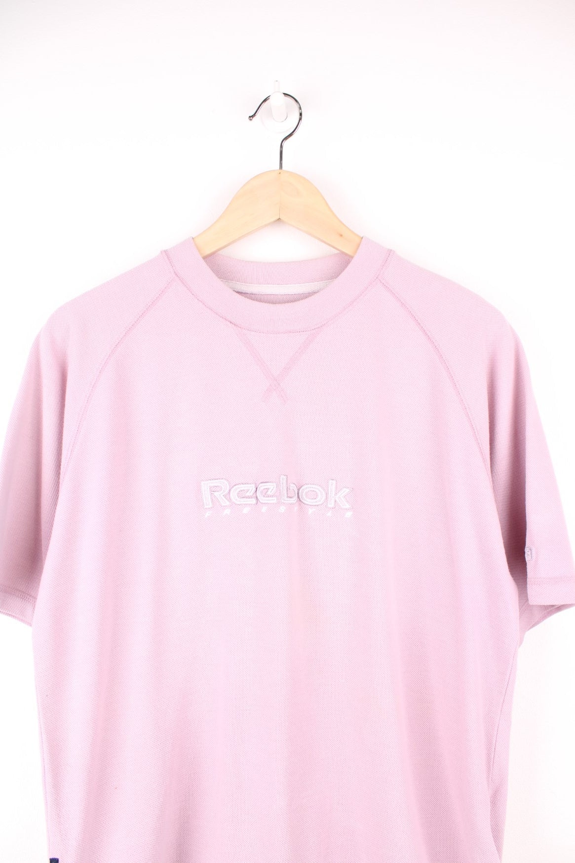 Pale pink Reebok Freestyle spellout t-shirt with small logo tag on left sleeve, and &