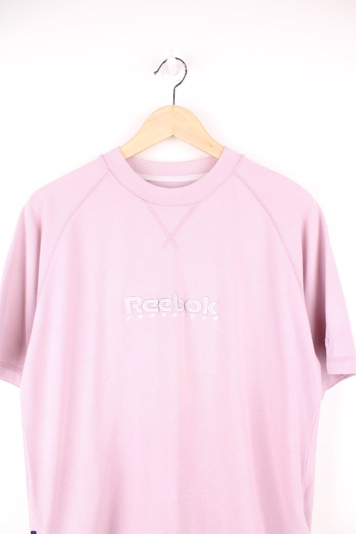 Pale pink Reebok Freestyle spellout t-shirt with small logo tag on left sleeve, and 'Freestyle' tag on lower right hem.