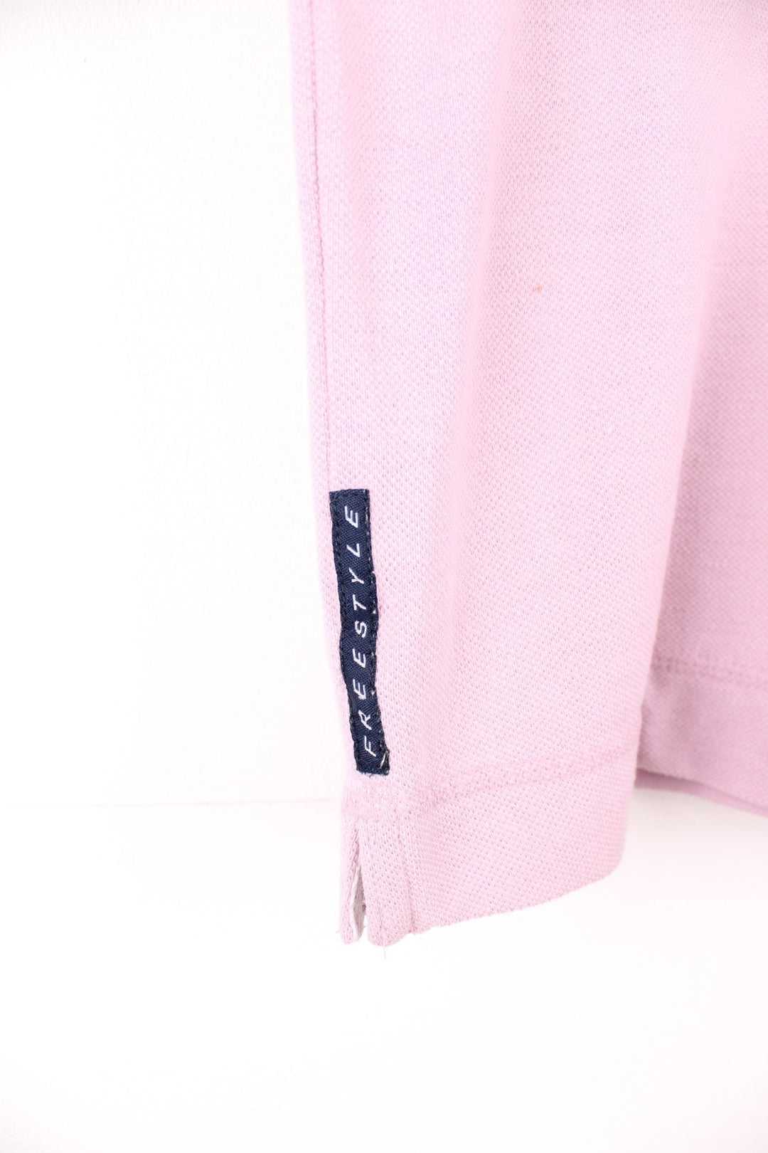 Pale pink Reebok Freestyle spellout t-shirt with small logo tag on left sleeve, and 'Freestyle' tag on lower right hem.