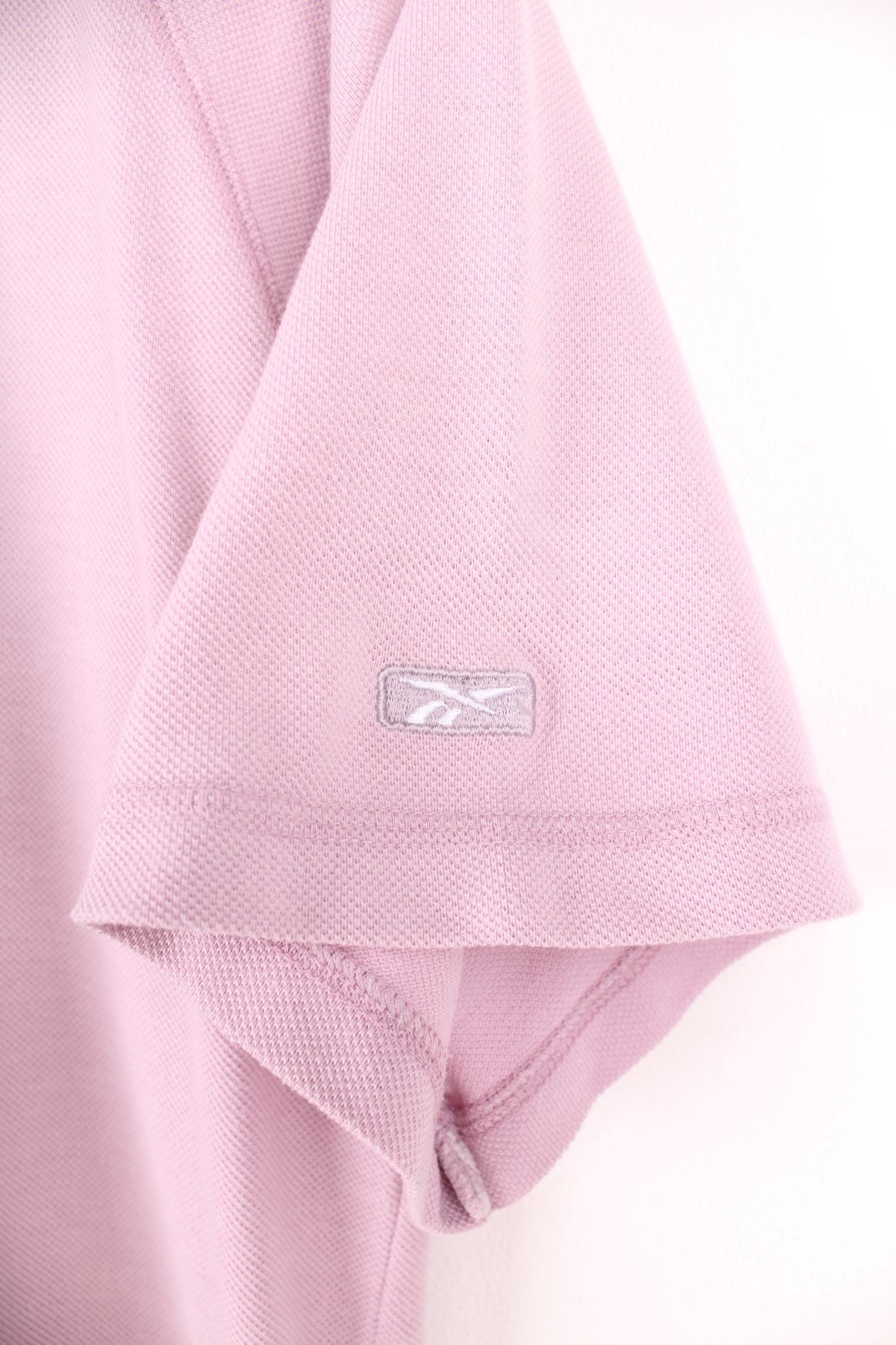 Pale pink Reebok Freestyle spellout t-shirt with small logo tag on left sleeve, and &