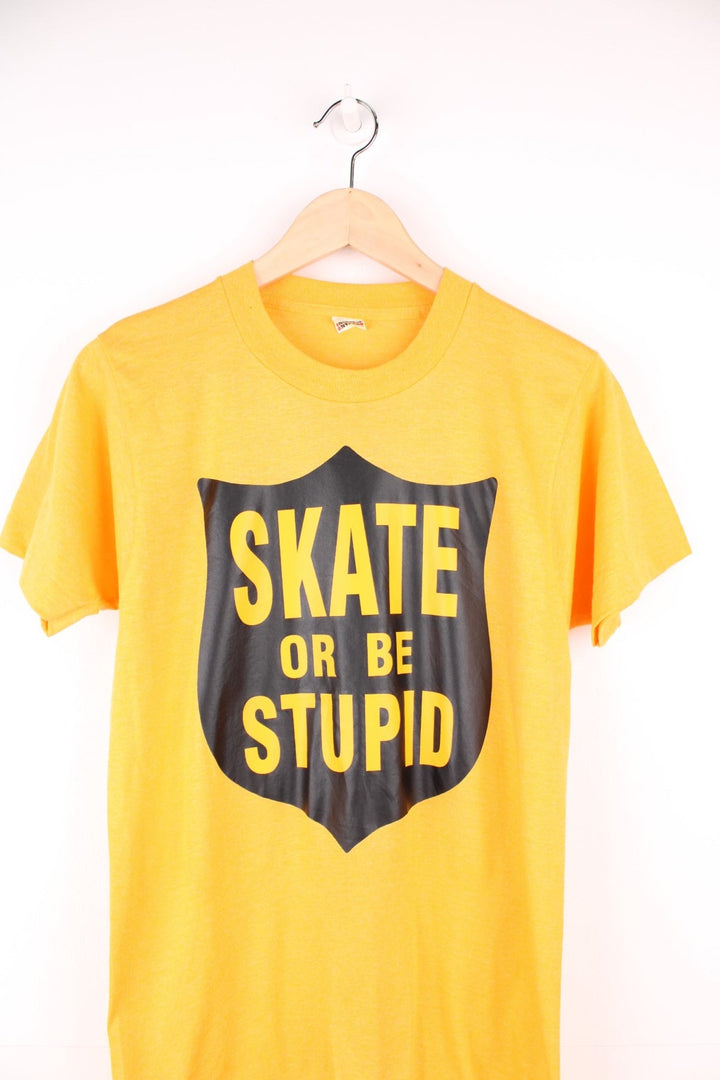 Yellow 'Skate or be stupid' spellout tee. 