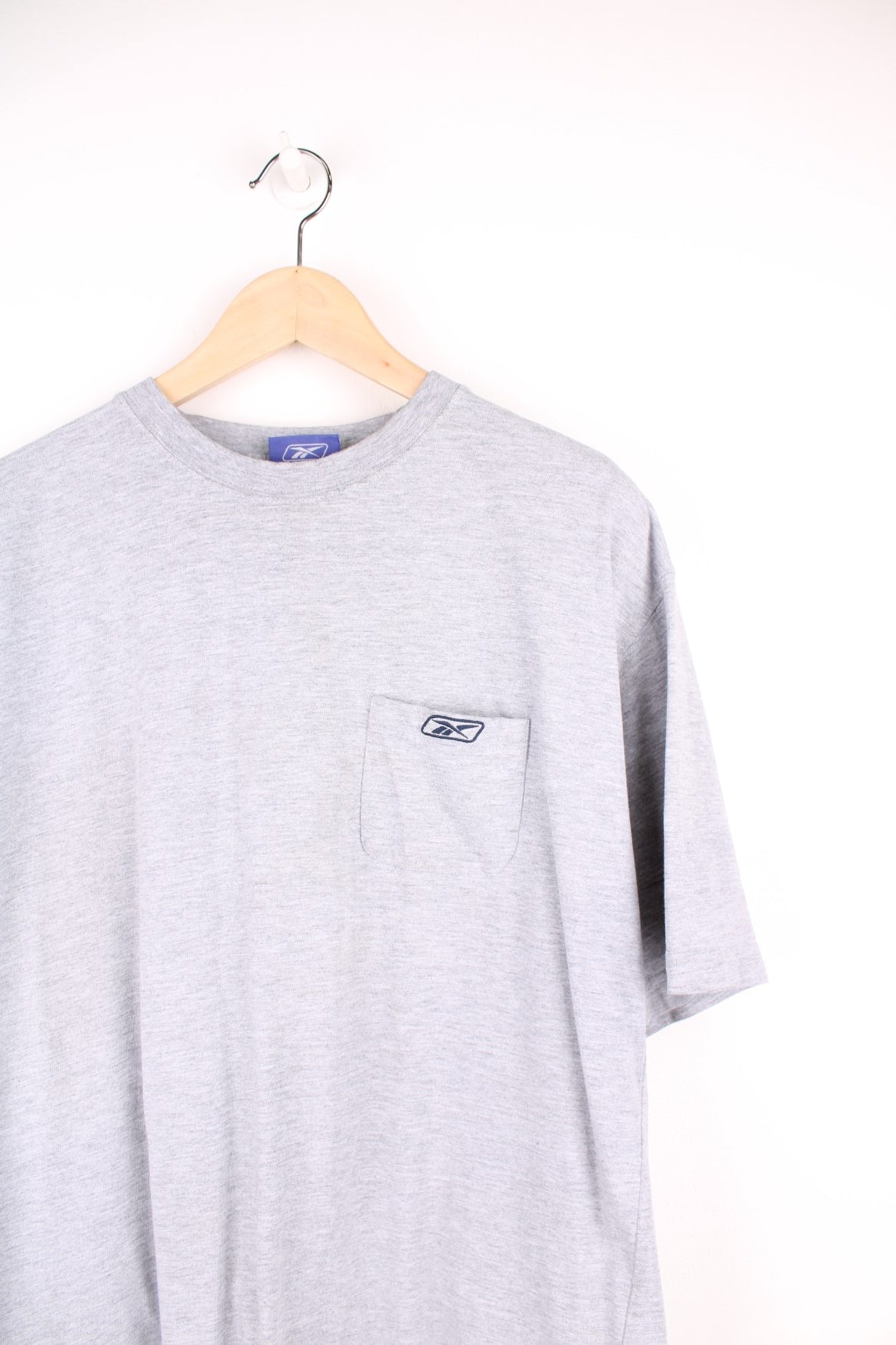 Grey Reebok tee with breast pocket and small embroidered logo. 