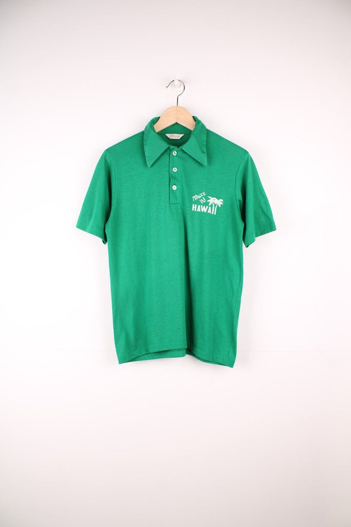 Vintage dagger collared tee in green with 'Praise '83 Hawaii' spellout and palm tree design on the upper right, with two buttons. 