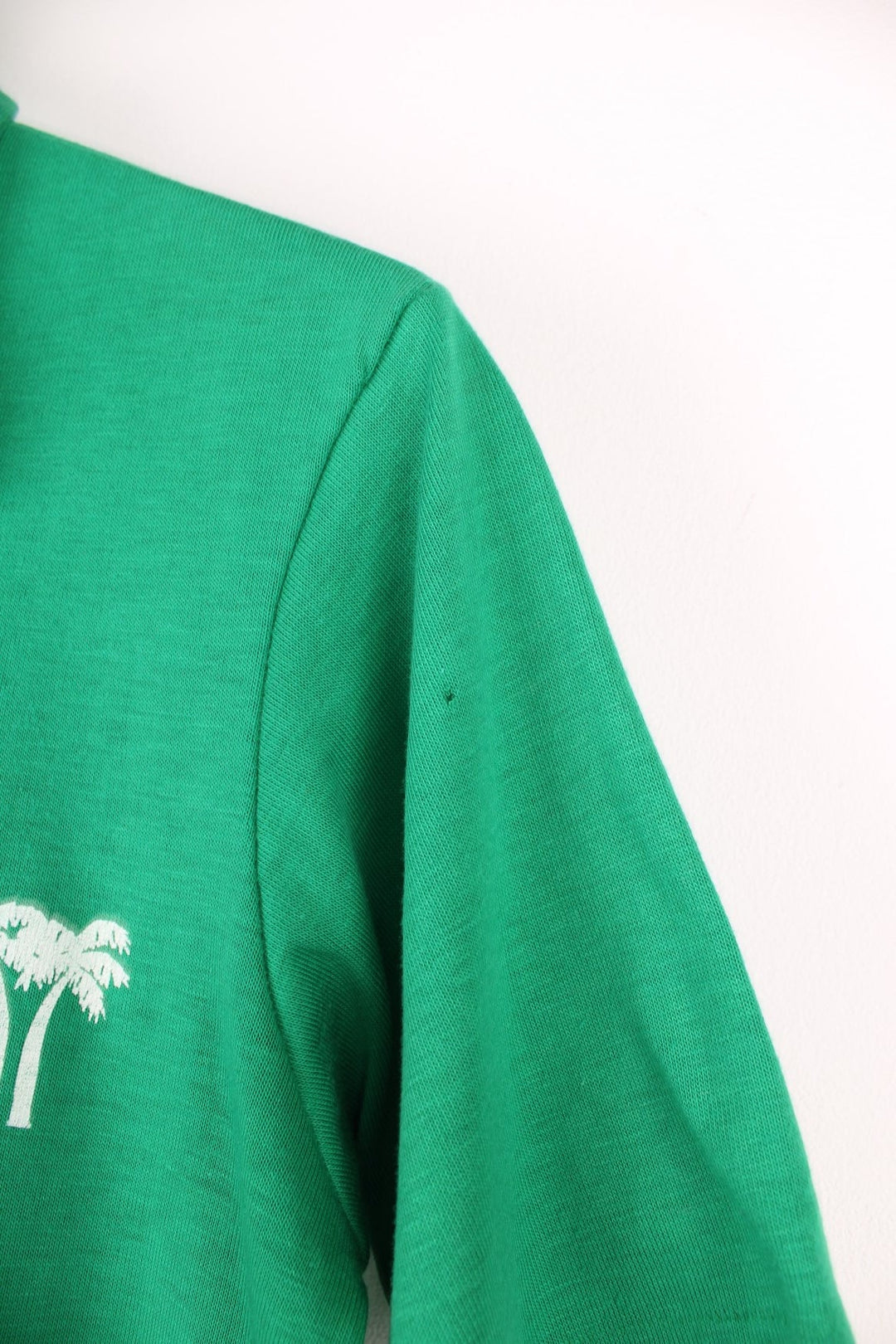 Vintage dagger collared tee in green with 'Praise '83 Hawaii' spellout and palm tree design on the upper right, with two buttons. 