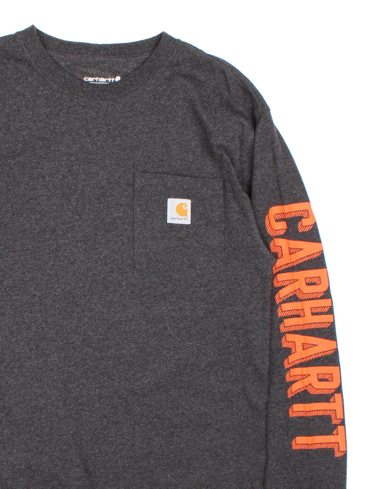 Carhartt long sleeve T-Shirt in grey with pocket and logo and graphic printed on the sleeve.