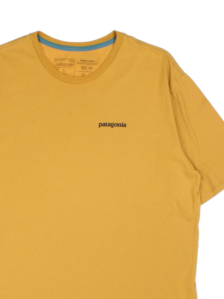 Patagonia Logo T-Shirt in a mustard yellow colourway with large logo graphic on the back and small logo on chest.