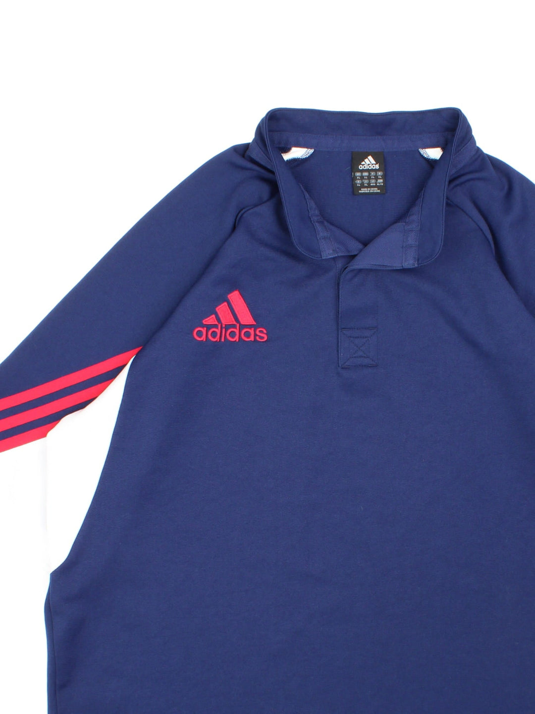 Vintage Adidas Polo Shirt in navy blue with the logo embroidered on the front and red and white stripped sleeve detail.