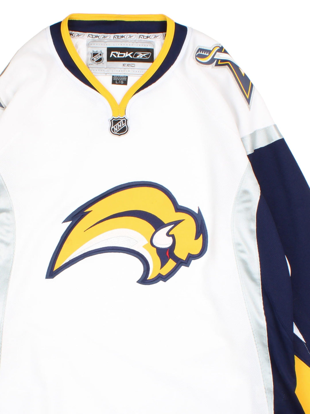 Buffalo Sabers Reebok NHL Jersey in the white colourway, features large logo on the front and shoulders with blue,yellow and silver striped panelling.