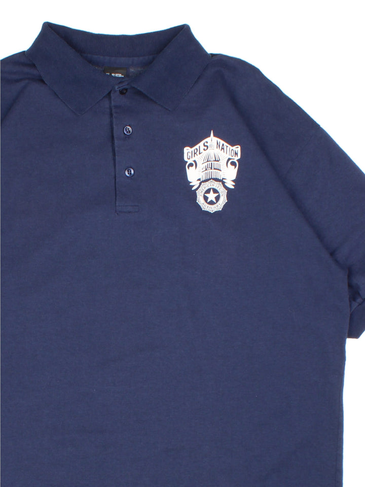 Vintage Girls Nation Auxilary Polo Shirt in a blue colourway, features button up and small printed logo on the front.