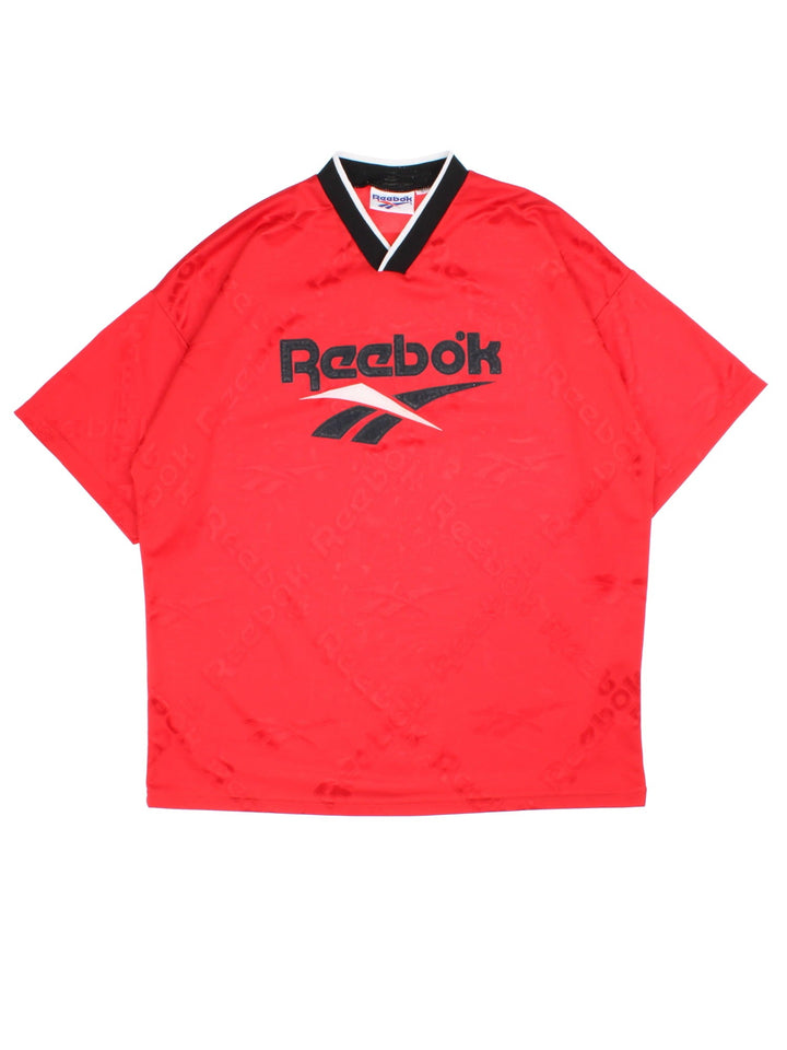 Vintage Reebok Training Top in a red colourway with printed logo fabric and spellout logo on the front.