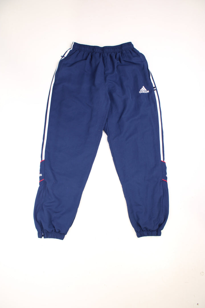 Adidas Tracksuit Bottoms in a blue colourway with the iconic three stripes going down the sides, has an elasticated waist with drawstring, cotton lining, and the logo embroidered on the front and back of the legs. 