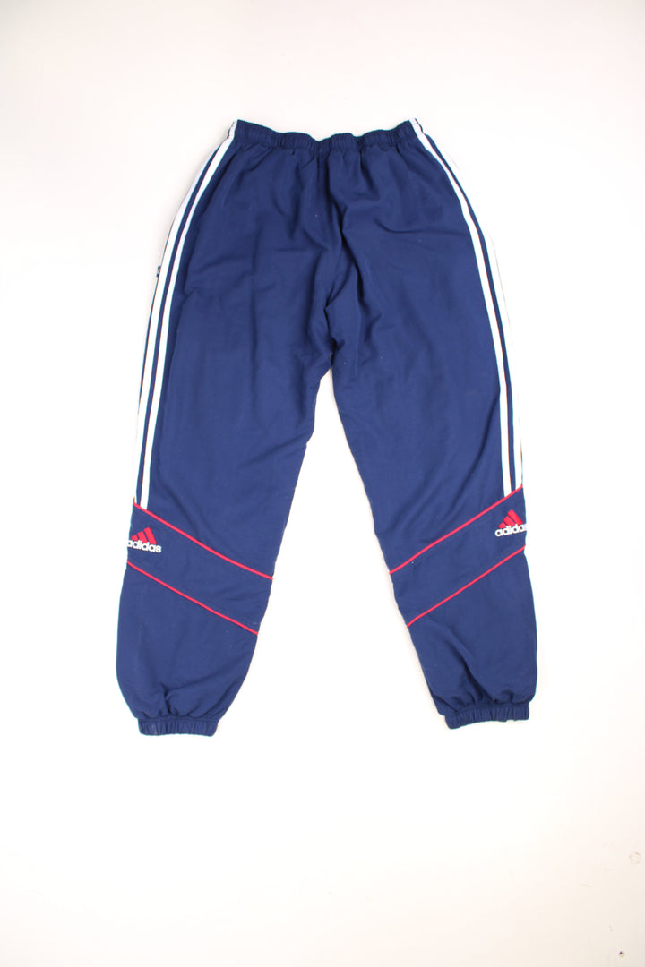  Tracksuit Bottoms in a  colourway with the iconic three stripes going down the sides, has an elasticated waist with drawstring, cotton lining, and the logo embroidered on the front and back of the legs. 