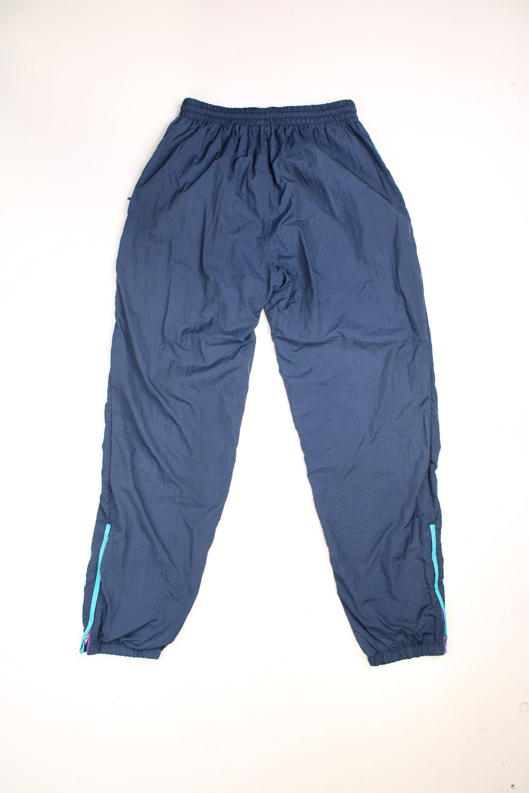 Vintage  Shell Tracksuit Bottoms in a  colourway, has an elasticated waist with drawstring, zip up side pockets, and the logo embroidered in purple on the front. 