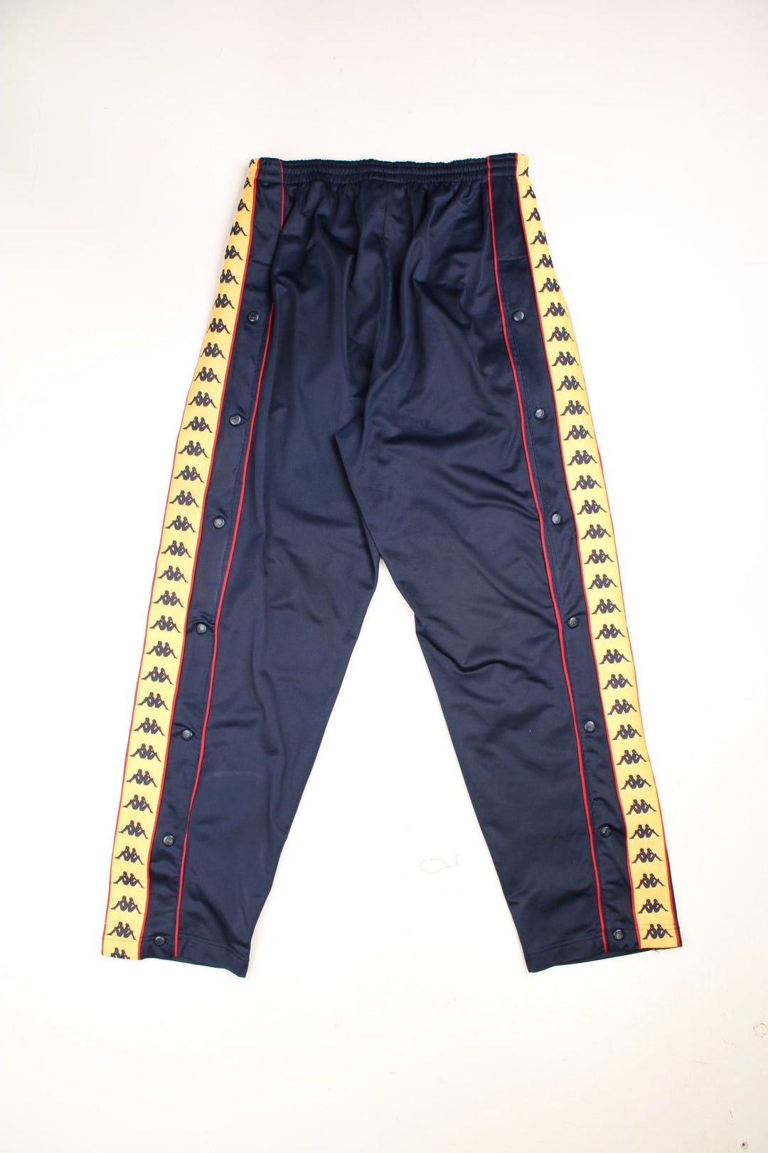 Vintage  Tracksuit Bottoms in a  colourway with orange and red stripes with the logo on going down the sides, has side pockets, and an elasticated waist with drawstring. 