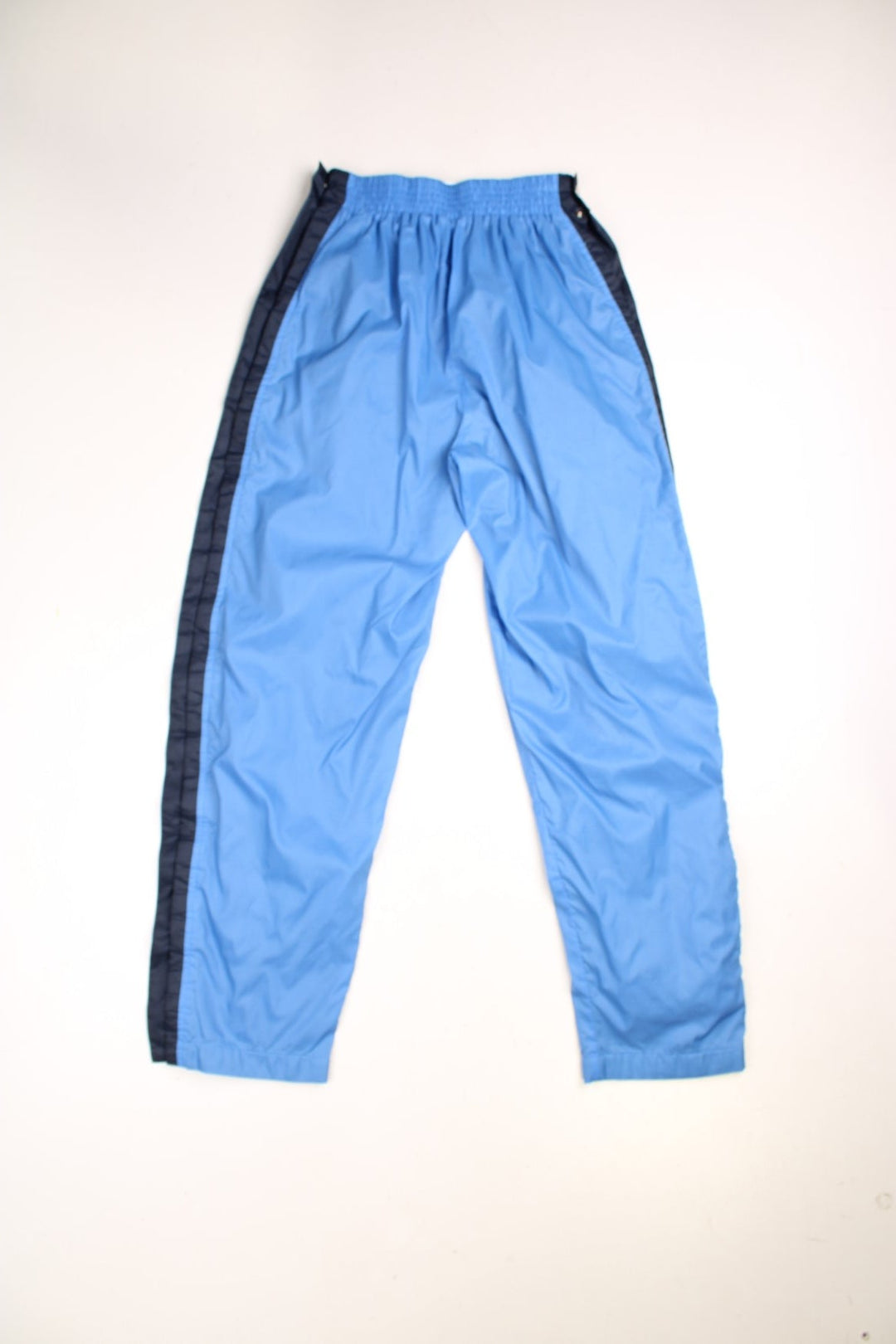 Vintage  Popper Tracksuit Bottoms in a  colourway with stripes going down the sides, has side pockets, and an elasticated waist. 