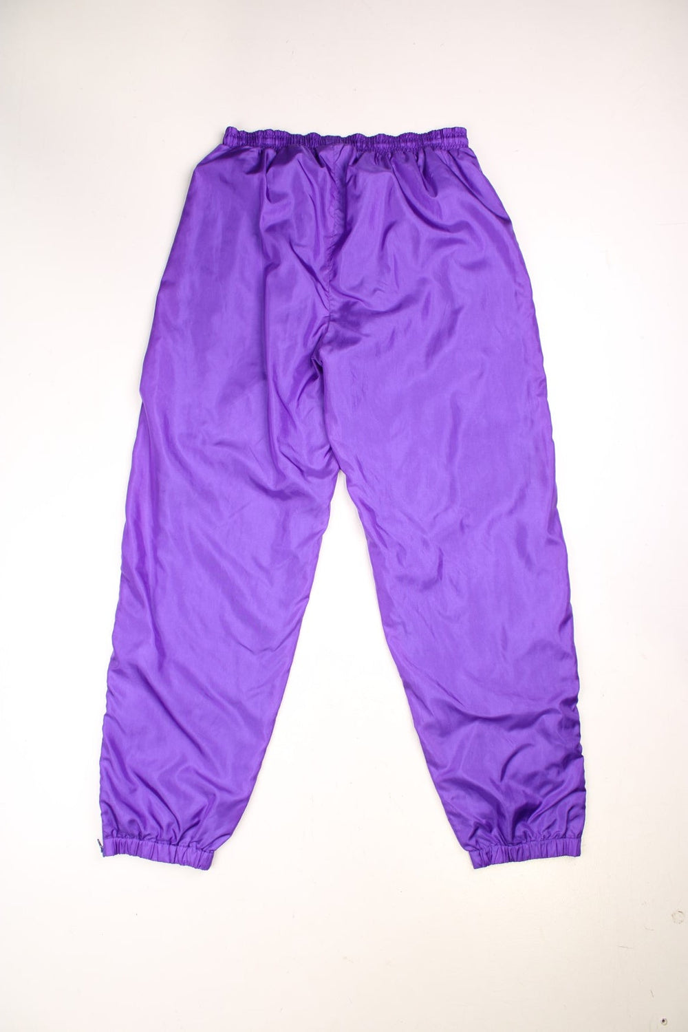 Vintage  USA Shell Tracksuit Bottoms in a  colourway, has zip up side pockets, an elasticated waist with drawstring, cotton lining, and the logo embroidered on the front. 