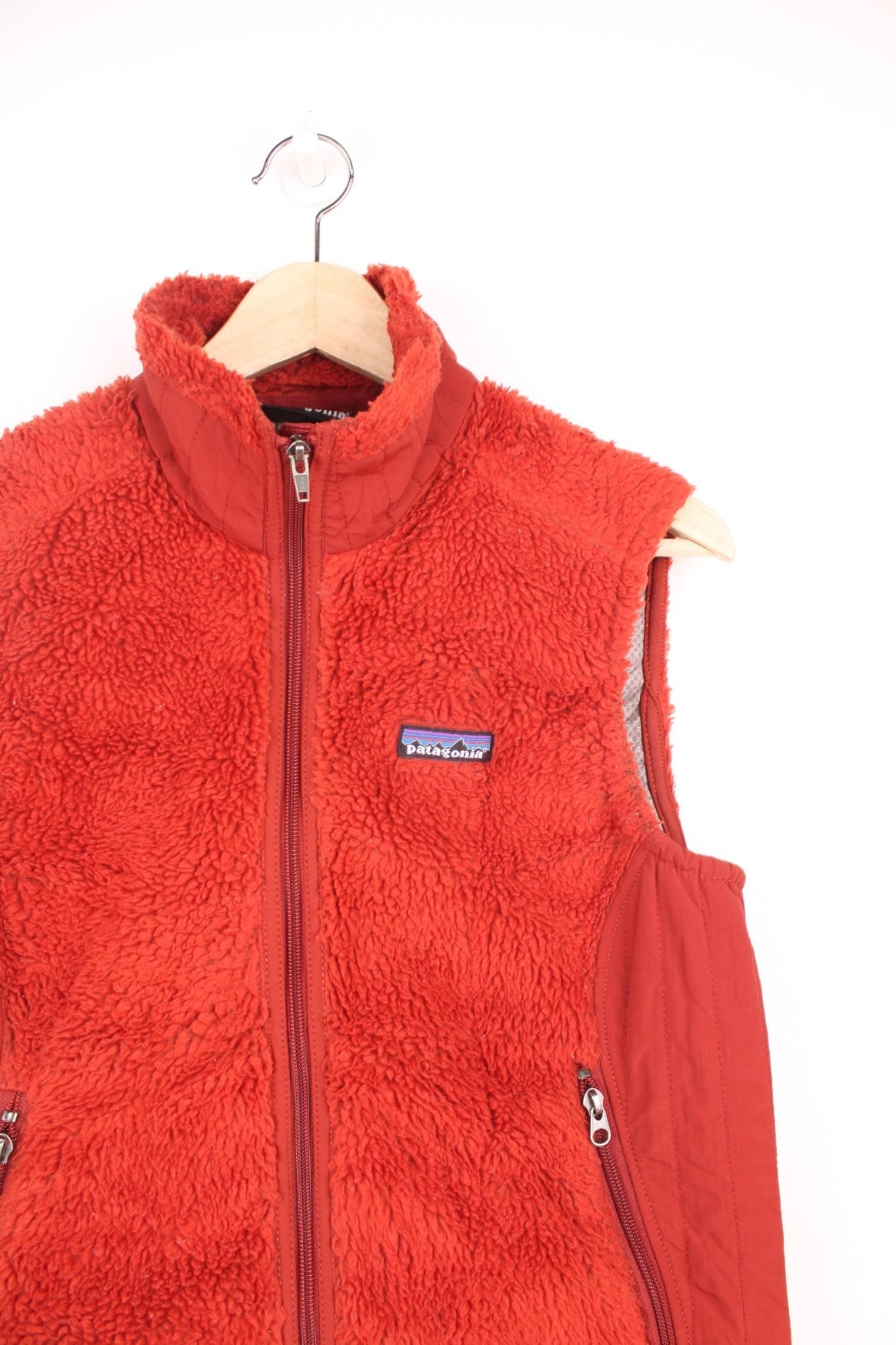 Patagonia zip through fleece gilet in deep red/burnt orange. Features embroidered logo on the chest.