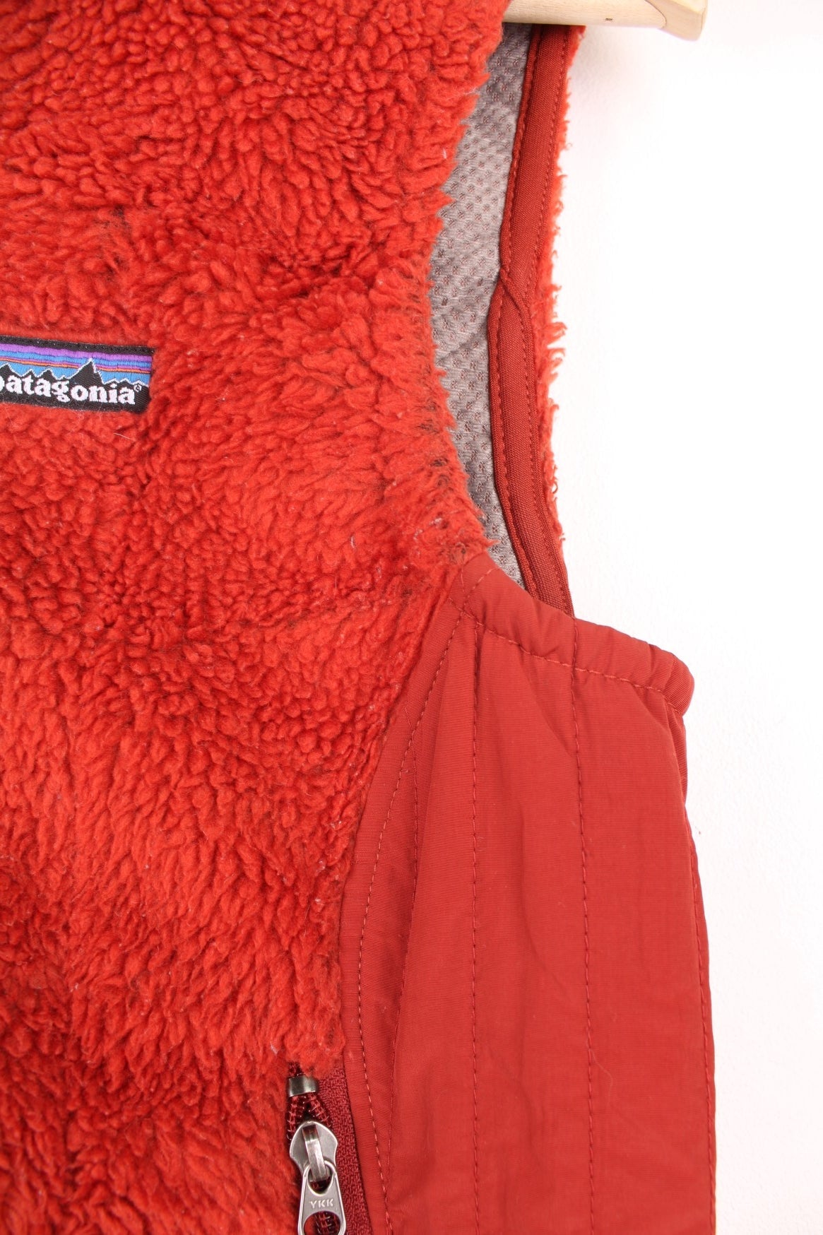 Patagonia zip through fleece gilet in deep red/burnt orange. Features embroidered logo on the chest.