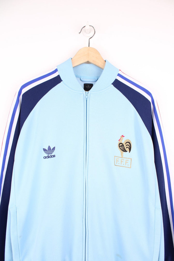 Adidas 2004 France football warm up tracksuit jacket in blue with stripes down the sleeve and logos on the chest. 