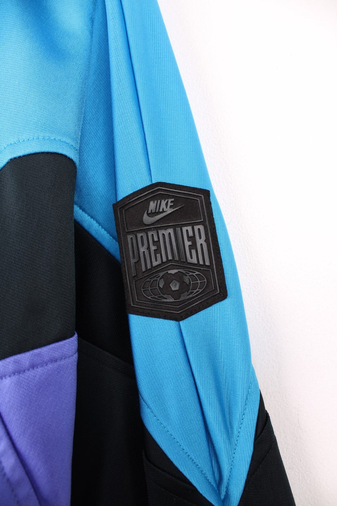 Vintage Nike Premier Soccer tracksuit top in blue, black and purple. Features embroidered logo on the chest and back.