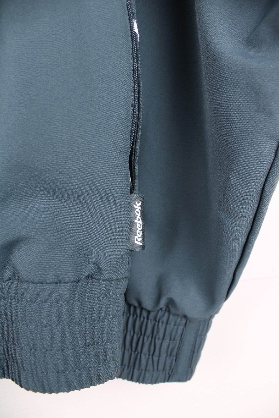 Reebok grey and blue zip through tracksuit top with embroidered logo on the chest.