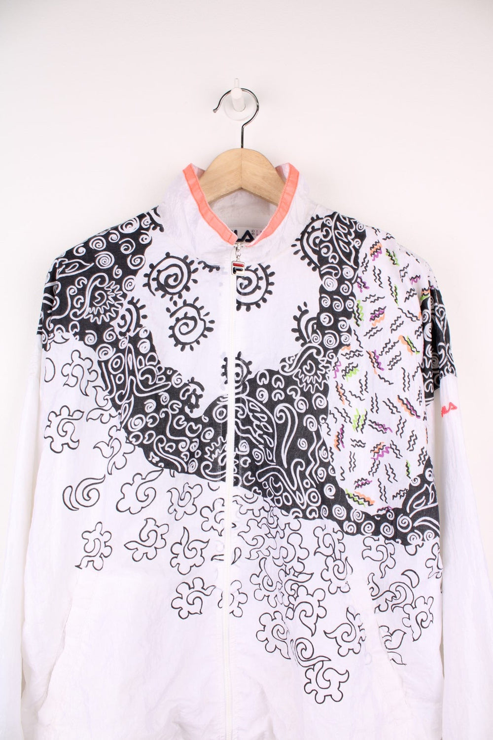 Vintage 90s Fila Shell Jacket in white with all over black swirl/squiggle pattern. Features embroidered logo on the sleeve.