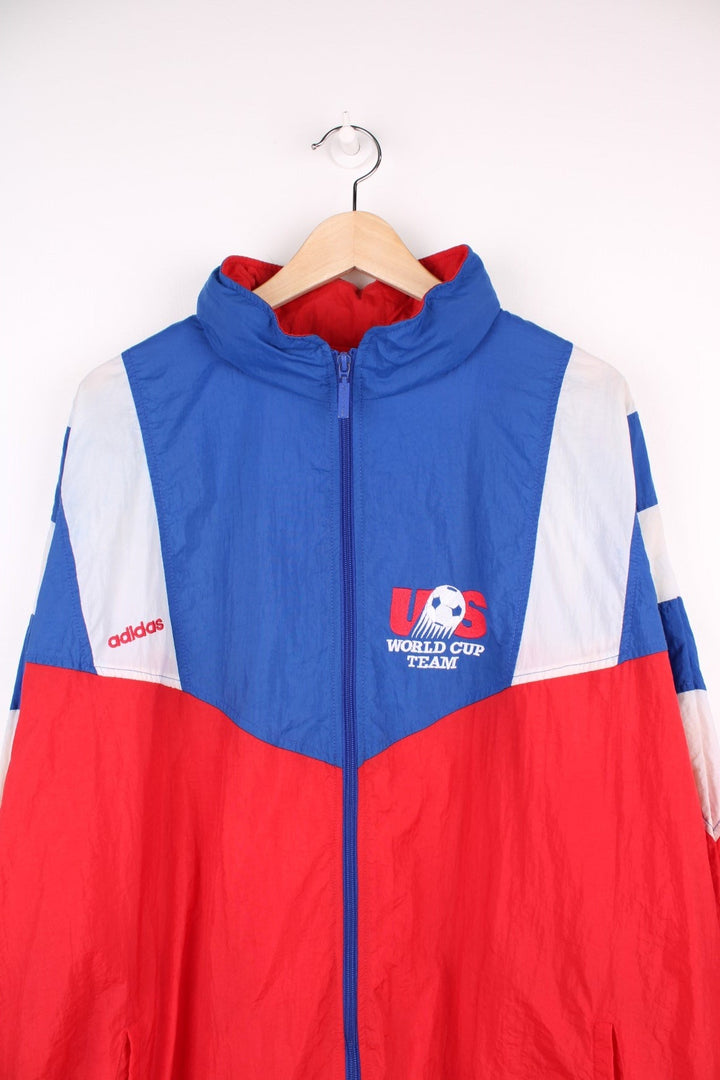 1994 Adidas FIFA World Cup team USA shell jacket in red, white, and blue with zip closure and embroidered team logos on the front and back. 