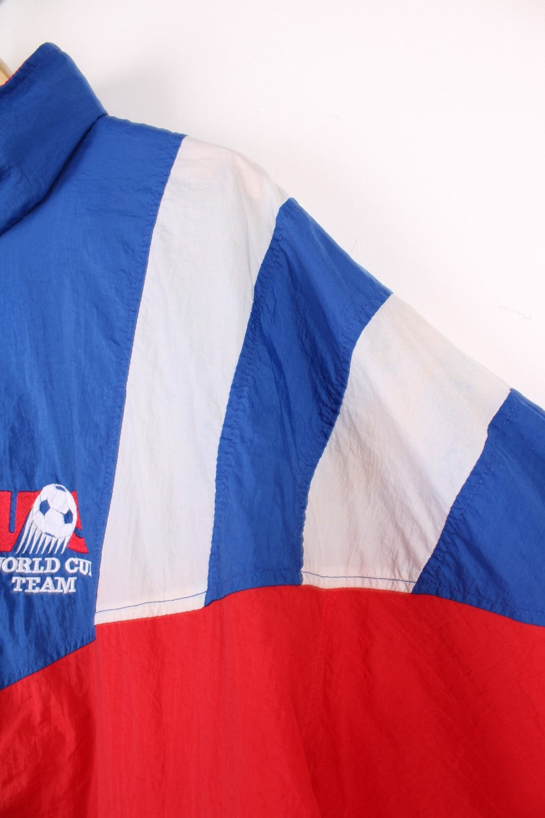 1994 Adidas FIFA World Cup team USA shell jacket in red, white, and blue with zip closure and embroidered team logos on the front and back. 