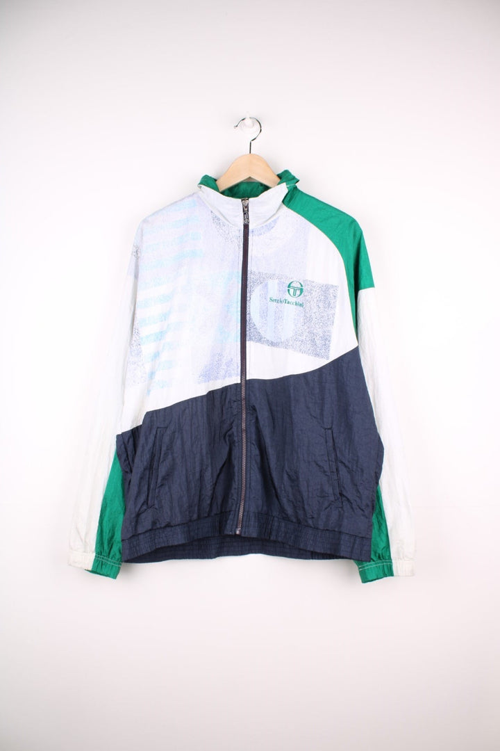 Sergio Tacchini track top/shell jacket in navy, white and green colourblocking, with two pockets and zip closure. 