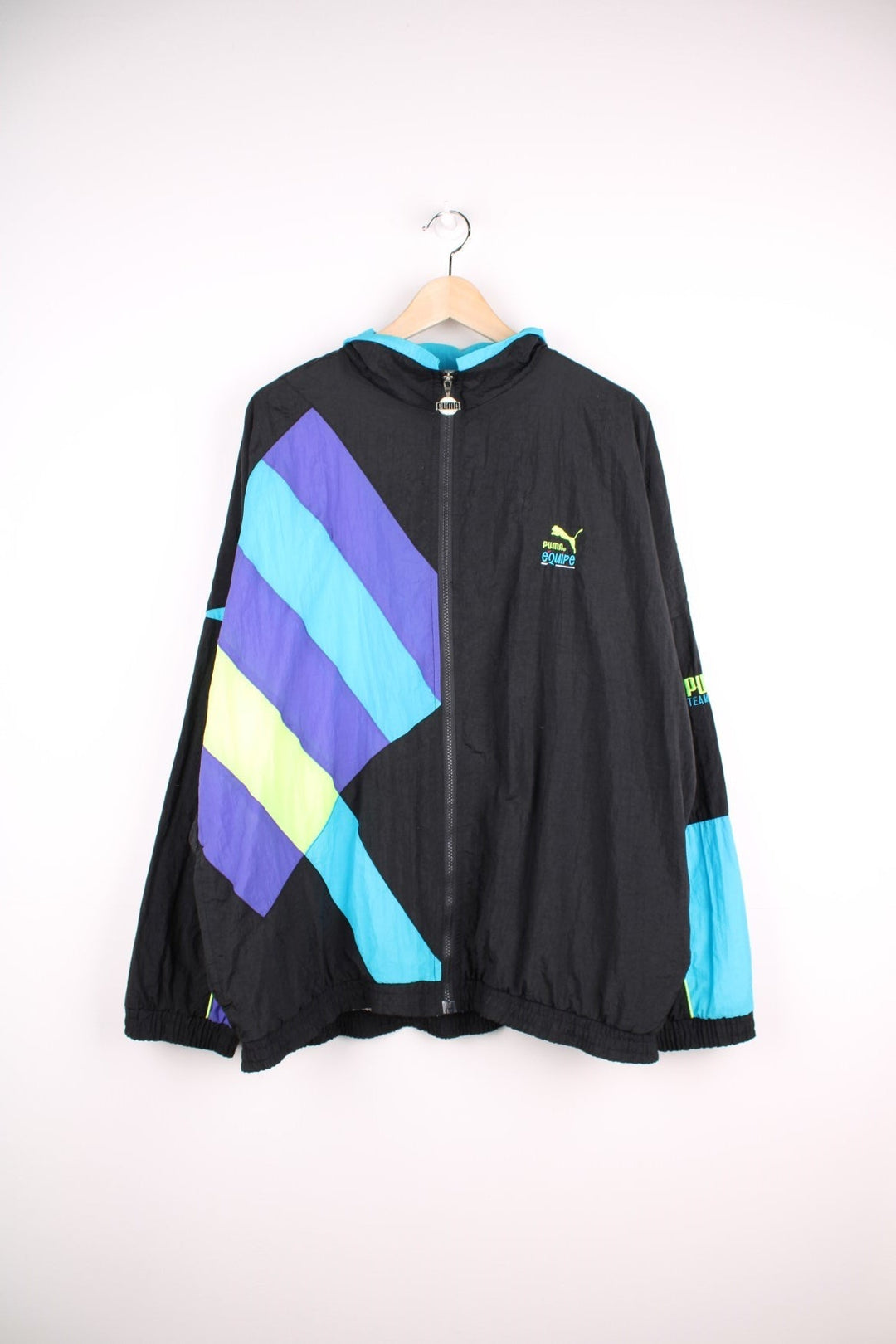 90s Puma Equipe track top/shell jacket in black with blue, green and purple accents, two pockets, zip closure and an embroidered logo.