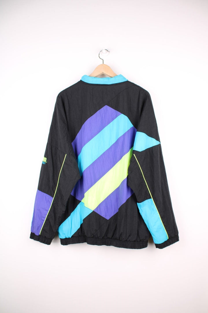 90s Puma Equipe track top/shell jacket in black with blue, green and purple accents, two pockets, zip closure and an embroidered logo.