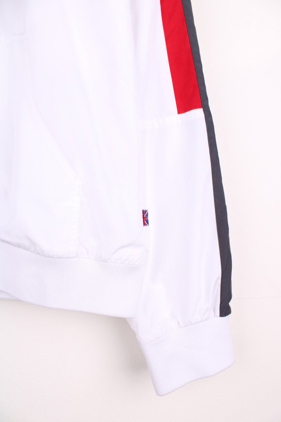 Reebok Classic zip-through tracksuit top in white with red and grey stripes on the sleeves, two pockets and embroidered logos on the chest and back.  