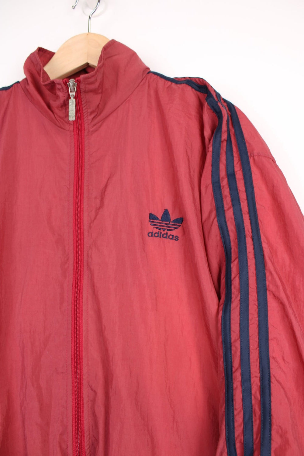 Late 90's Adidas red lightweight zip through tracksuit top features navy blue three stripe details down the sleeves