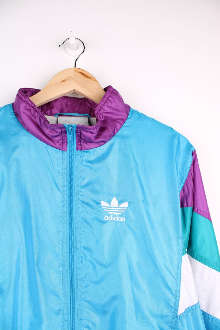 Vintage  Tracksuit Jacket in a , purple and white patterned colourway, zip up closure and has side pockets, cotton lining, and the logo embroidered on the front.