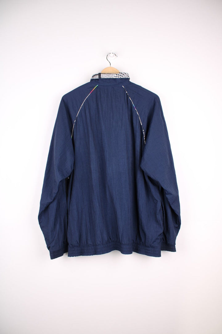  Tracksuit Jacket in a navy  colourway with patterned stripes going around the sides, zip up closure and has side pockets, cotton lining, and the logo embroidered on the front.