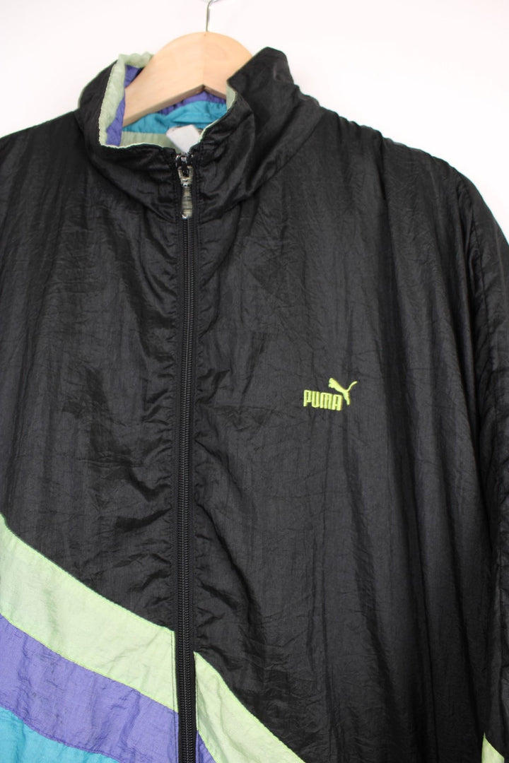 90's Puma black zip through shell jacket, features green, purple and blue stripes across the front 