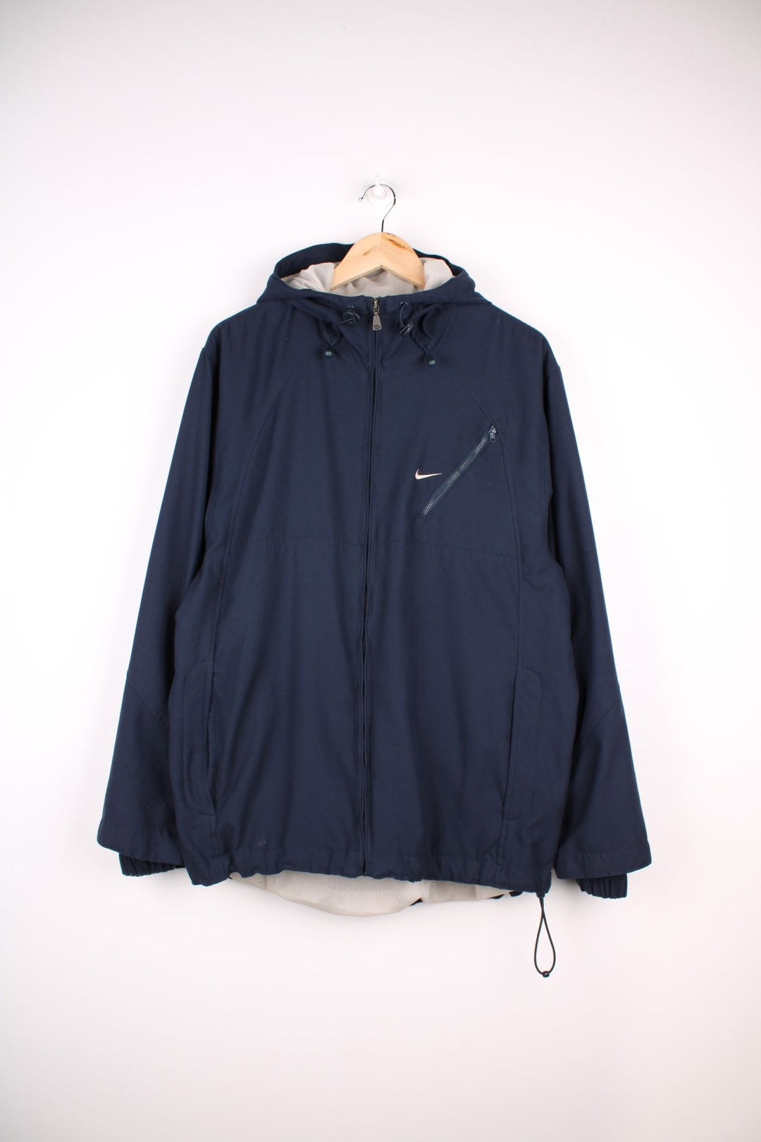 Y2K Nike Jacket in a navy blue colourway, zip up closure and has multiple pockets, mesh lining, hooded, and has the swoosh logo embroidered on the front and back.