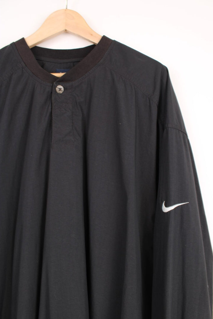 Nike golfing all black nylon training top with 1/4 button up detail and signature swoosh logo on the shoulder