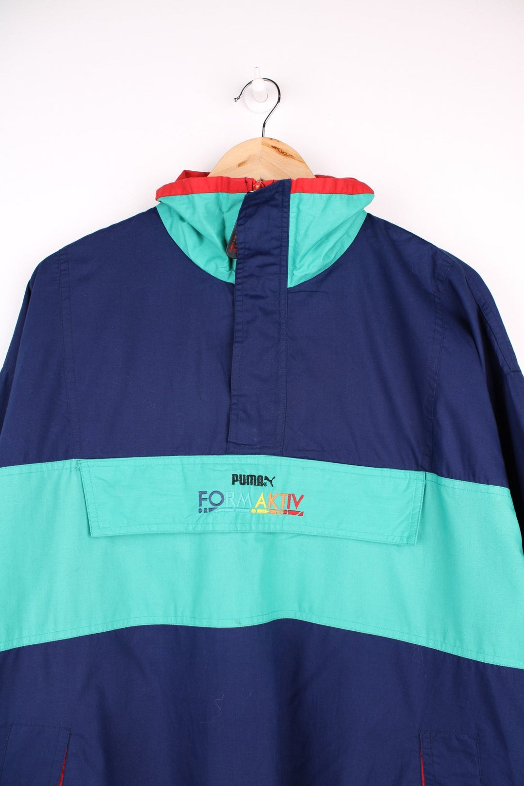 Vintage  Formaktiv Pullover Windbreaker in a navy  and green colourway, half zip up closure, multiple pockets, and has the spell out logo embroidered across the front and printed on the left sleeve.