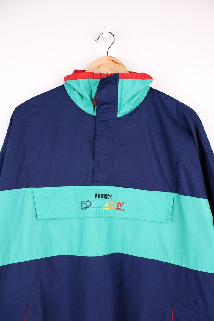 Vintage  Formaktiv Pullover Windbreaker in a navy  and green colourway, half zip up closure, multiple pockets, and has the spell out logo embroidered across the front and printed on the left sleeve.