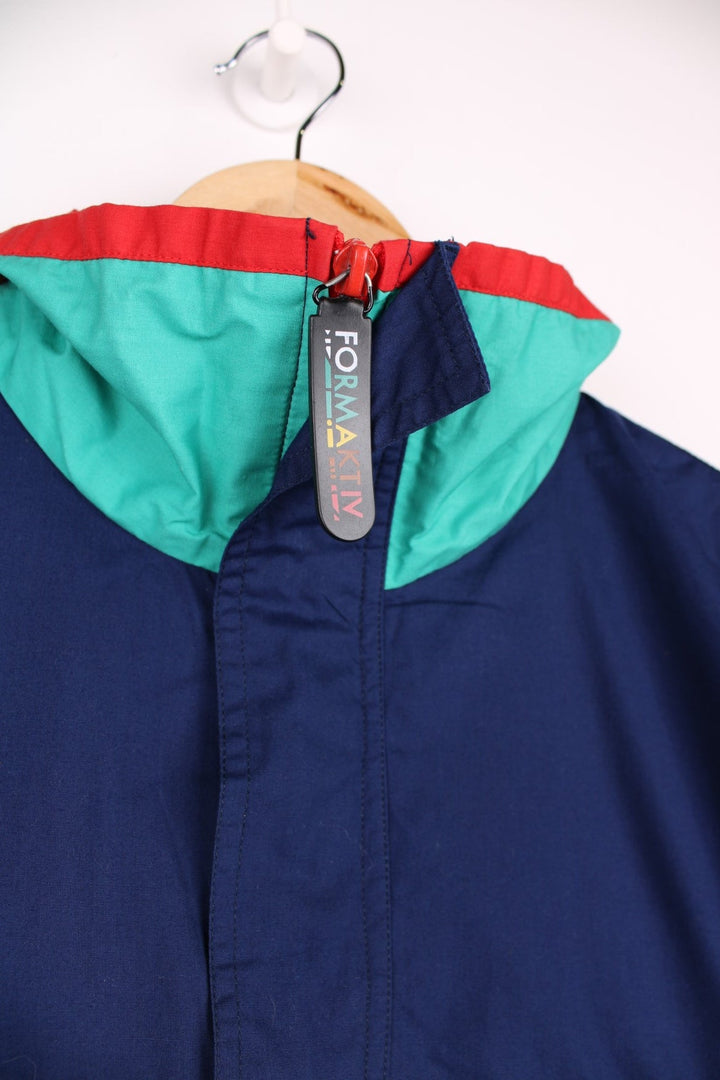 Vintage  Formaktiv Pullover Windbreaker in a navy  and green colourway, half zip up closure, multiple pockets, and has the spell out logo embroidered across the front and printed on the left sleeve.